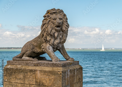 A stone lion sits proudly on the seafront in Cowes  Isle of Wight  England  looking over the Solent on a sunny day during Cowes Week.