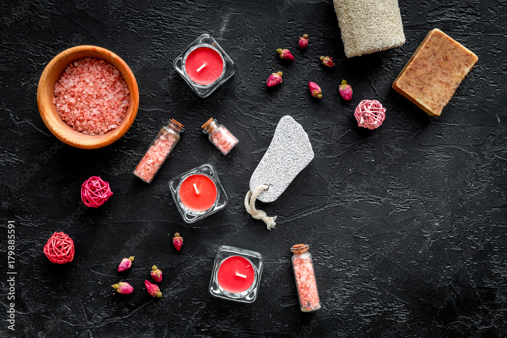 Romantic set for foot spa. Candles, salt, pumice stone, soap on black background top view copyspace Romantic set for foot spa. Candles, salt, pumice stone, soap on black background top view copyspace