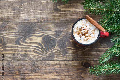Christmas hot chocolate with marshmallows and cinnamon on the wooden background. Top view and copy space.