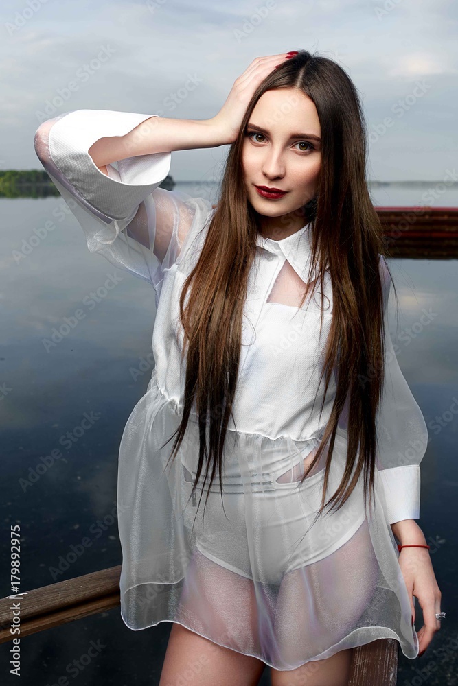 beautiful white girl on a pier near water