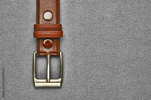 leather belt with a buckle on a gray background