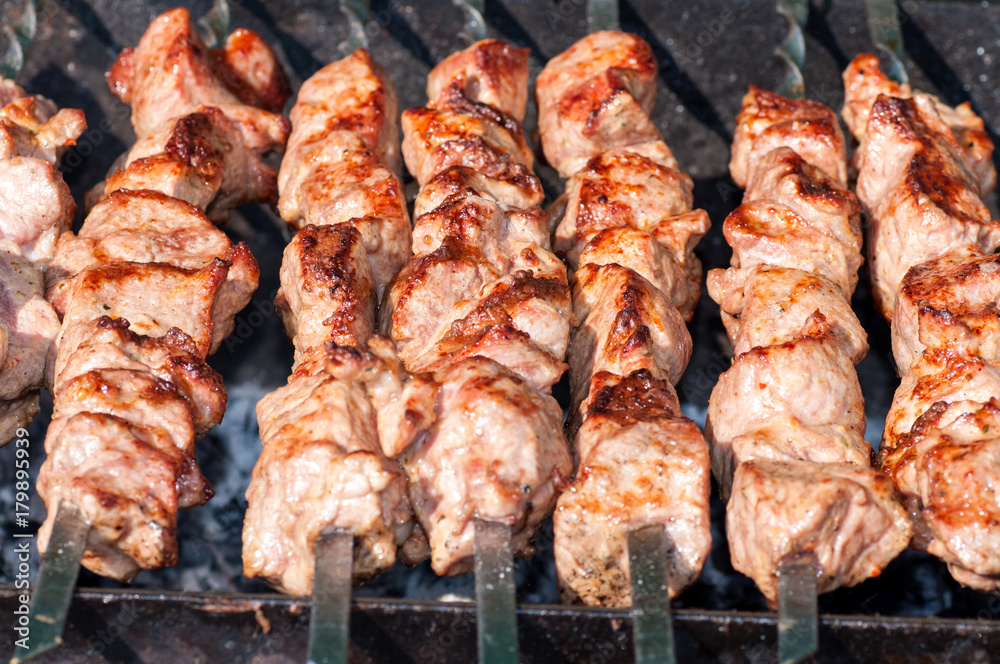 skewers fried meat on a grill
