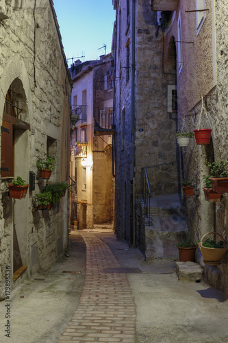 Narrow street with flowers in the old town Peille in France. Night view © arbalest