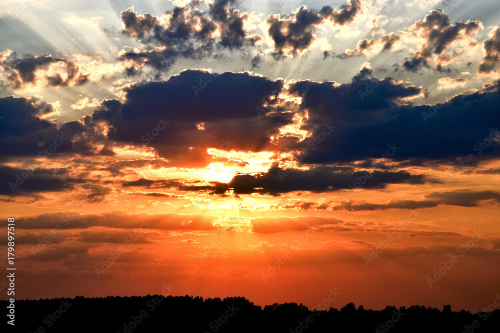 Dramatic sunset sky with dark clouds and bright orange light. Dramatic sunset sky with dark clouds and bright orange light.