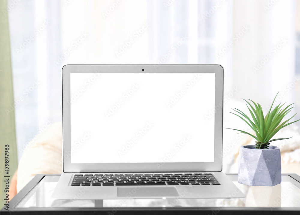 Modern laptop with blank screen on table at home Modern laptop with blank screen on table at home