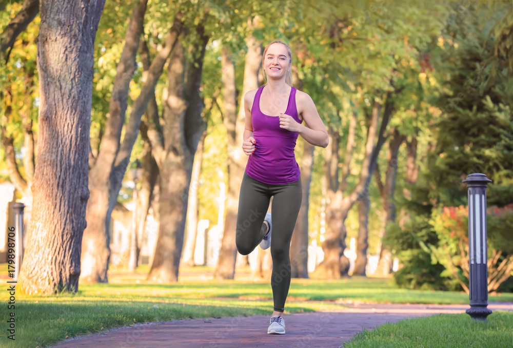 Sporty young woman running in park Sporty young woman running in park