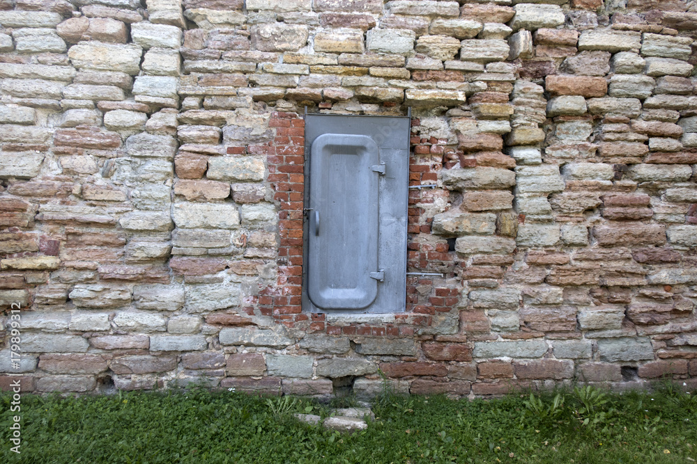 old iron door in the old brick wall old iron door in the old brick wall