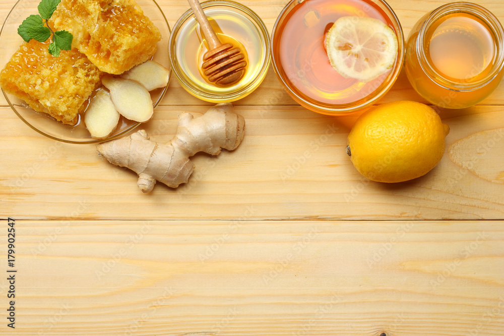 healthy background. honey, honeycomb, lemon, tea, ginger on light wooden table. Top view with copy space