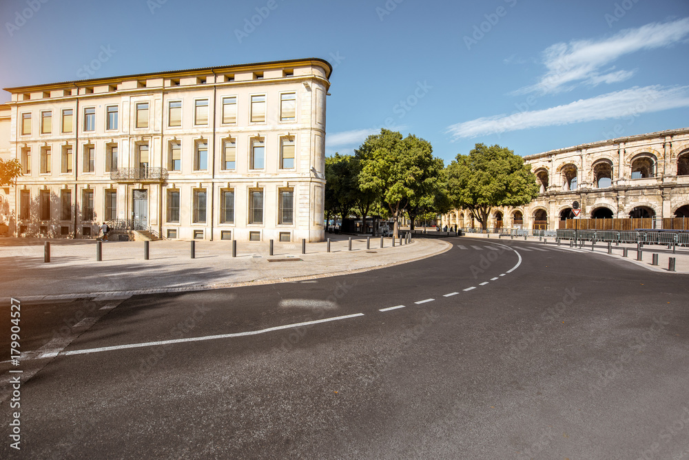 Morning street view with roman amphitheater building in Nimes city on southern france
