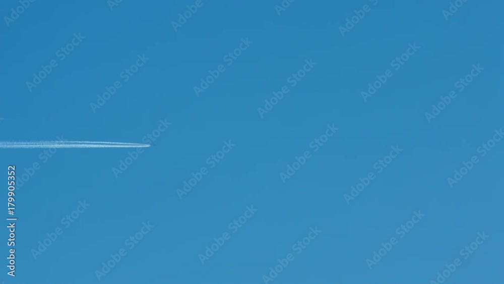 Airplane vapour trails across clear blue sky Airplane vapour trails across clear blue sky