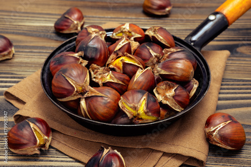 chestnuts in a pan on wooden background