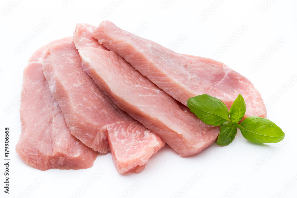 Fresh pork fillet with basil on a white background.