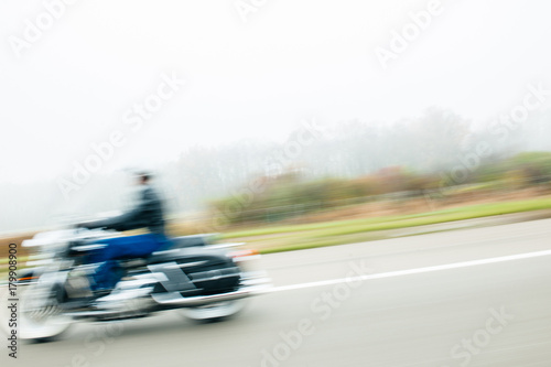 Blur motion of cool hipster biker motorcyclist on German autobahn highway