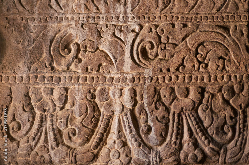Background of Indian rock-cut architecture. Wall with carved patterns in 6th century cave temple, India