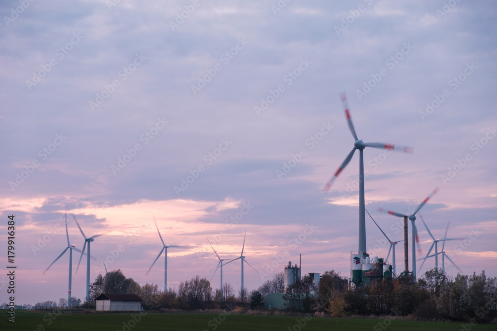 wind turbines on a field during sunset