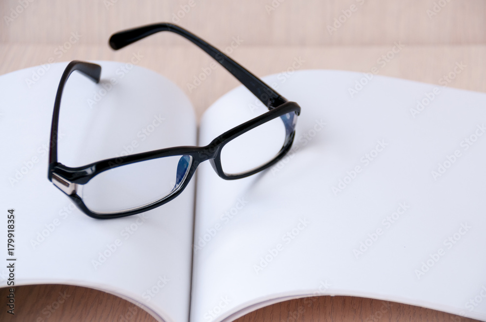 Black glasses on an open blank album Black glasses on an open blank album