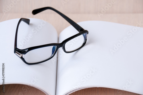 Black glasses on an open blank album