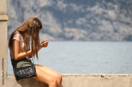 Italy, Malcesine, garda lake. Palazzo dei Capitani. Girl with our smartphone, relax photo