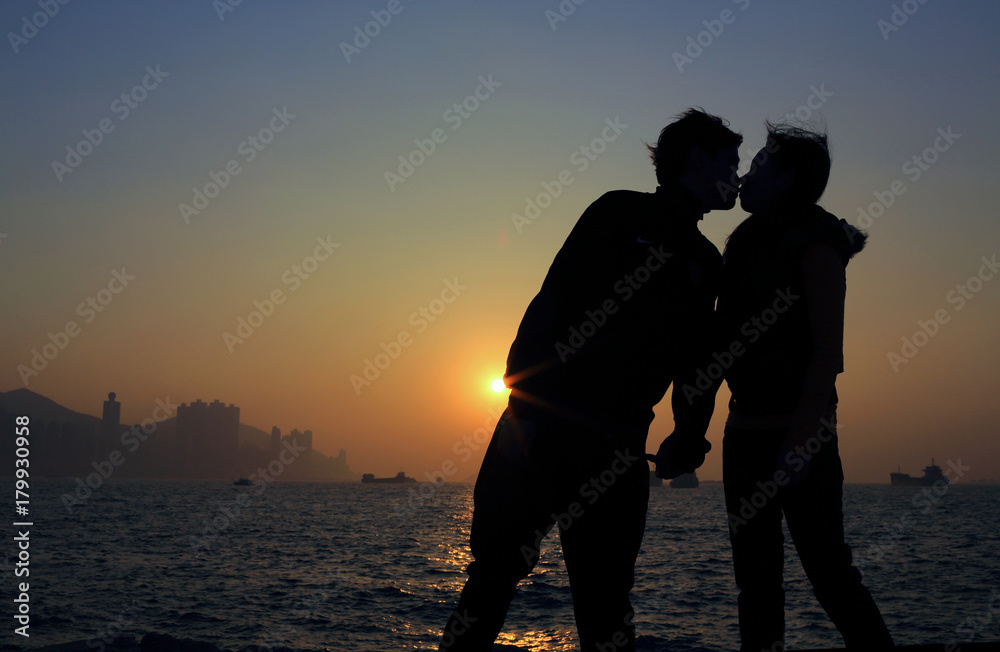 boy kiss his girl in valentines day under the city of sunset