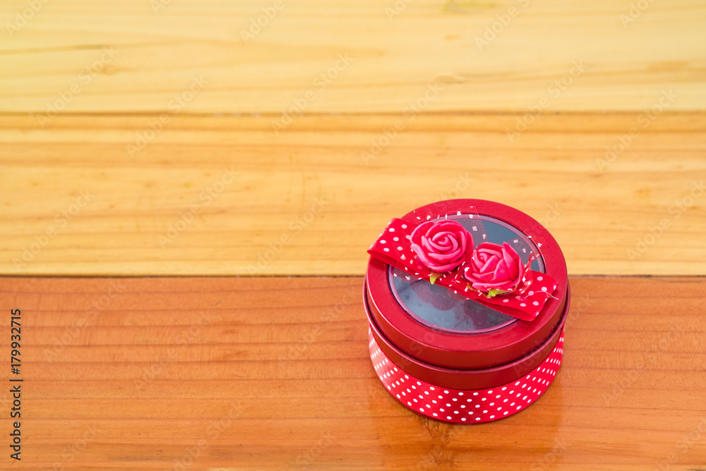 Round red gift box with ribbon bow on wooden table with copy space for season or greeting and merry concept. Round red gift box with ribbon bow on wooden table with copy space for season or greeting and merry concept.