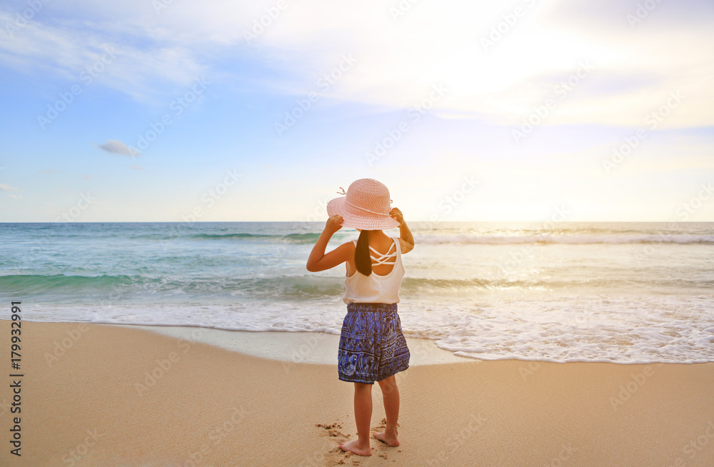 Rear view little girl wear straw hat standing at the beach. Rear view little girl wear straw hat standing at the beach.