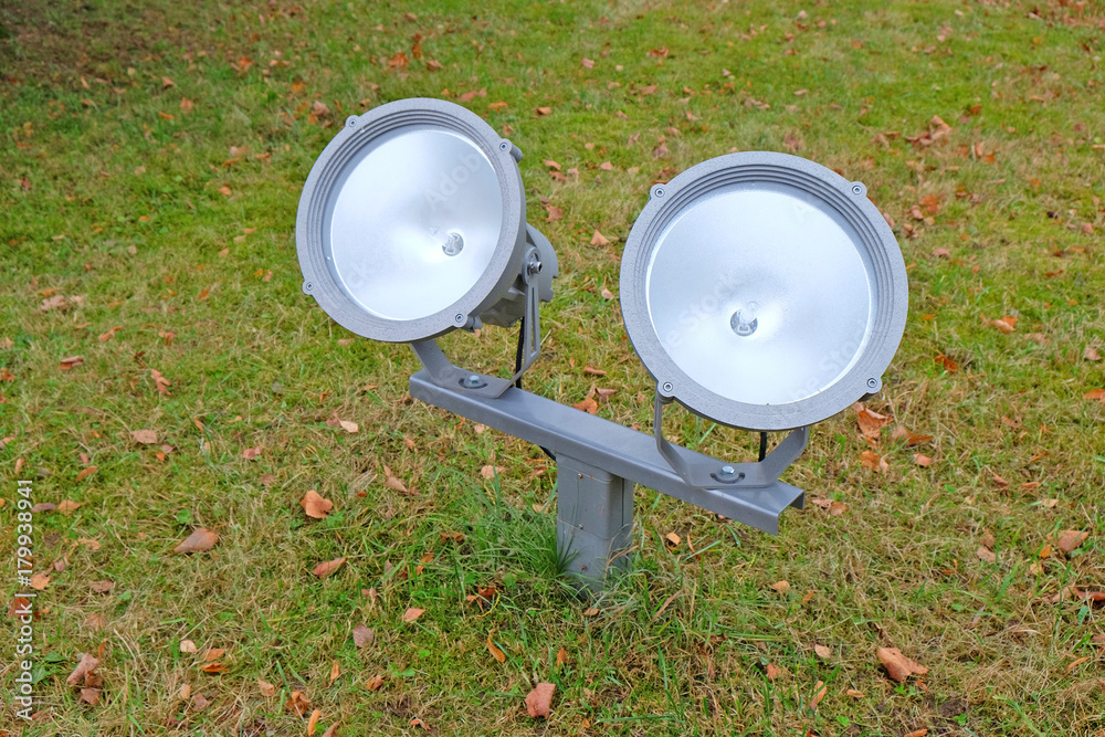 twin floodlights on the lawn to illuminate the facade of the building in the Park