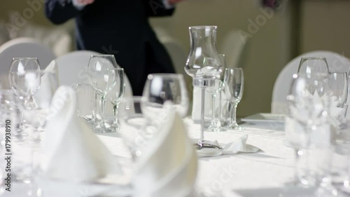 Professional waiter serving dessert on banquet table at restaurant photo