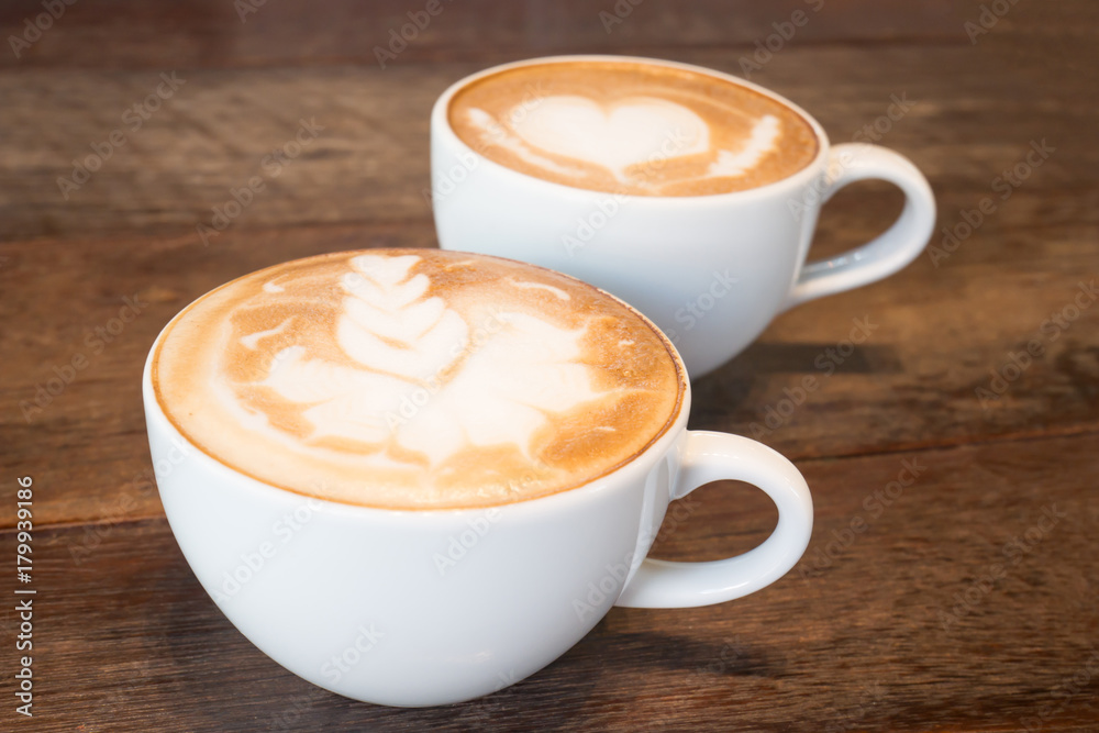 Two cups of coffee latte art on wooden table Two cups of coffee latte art on wooden table