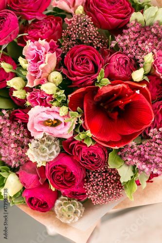 beautiful bouquet of mixed flowers into a vase on wooden table