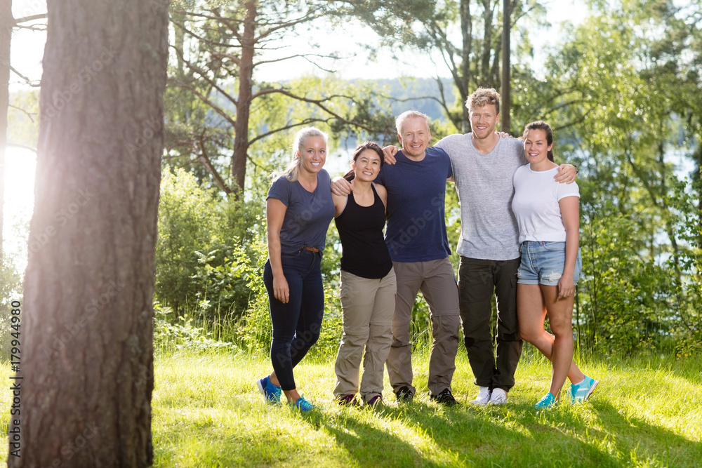 Portrait Of Confident Friends Standing Arms Around In Forest Portrait Of Confident Friends Standing Arms Around In Forest