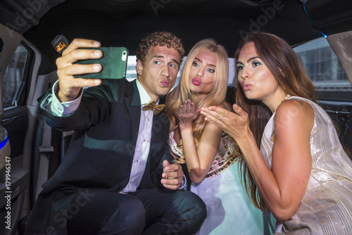 Friends taking a selfie in the back of a limousine