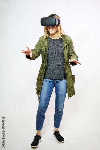 young woman wearing virtual reality goggles white background