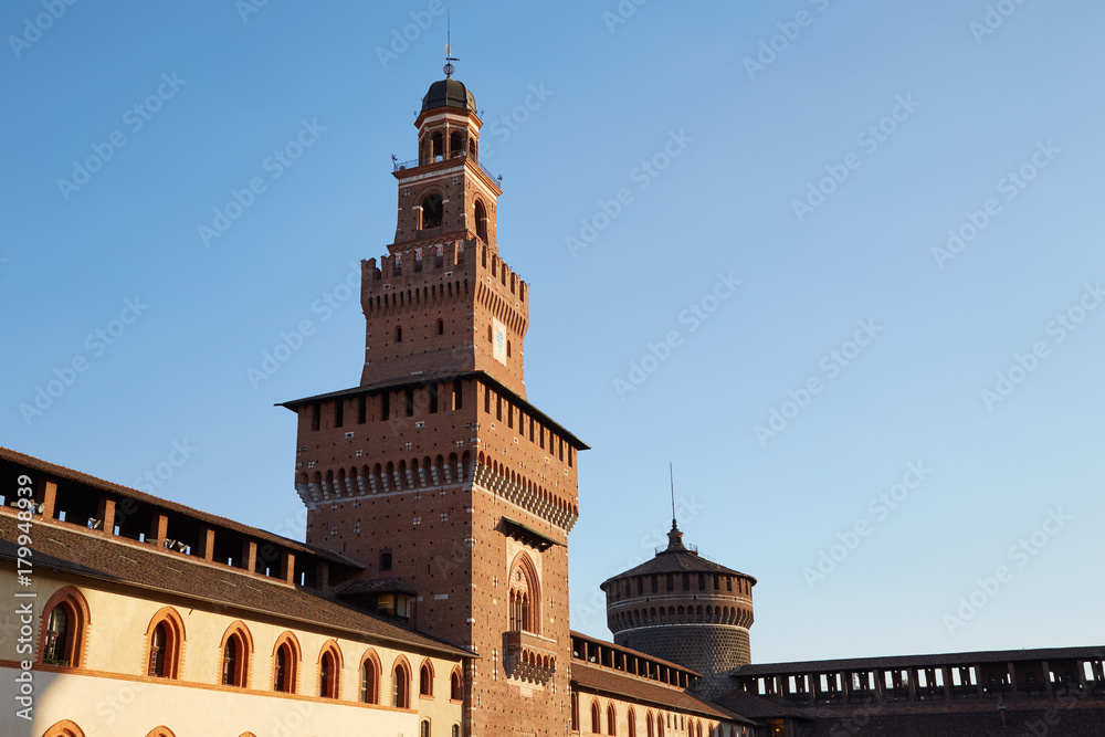 Fragment of the castle wall with towers of Castello Sforzesco in the evening Milan, Italy