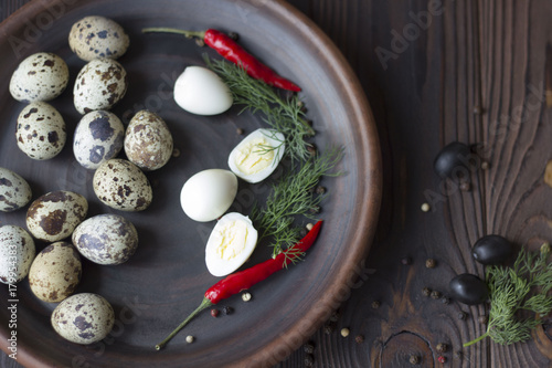 quail eggs, olives, chili and spices on a wooden table