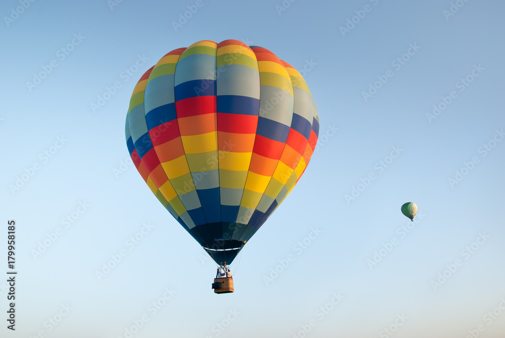 Fototapeta premium Two colorful hot air balloons on blue sky background