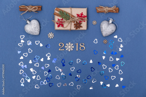 Concept christmas background with decorations, xmas tree and gift boxes on blue background. New year card. Empty space for your text. flatlay. Sigh symbol from number 2018 photo