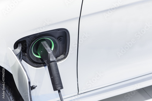 The electric car charger plugged in to the socket.The modern electric car charging the battery