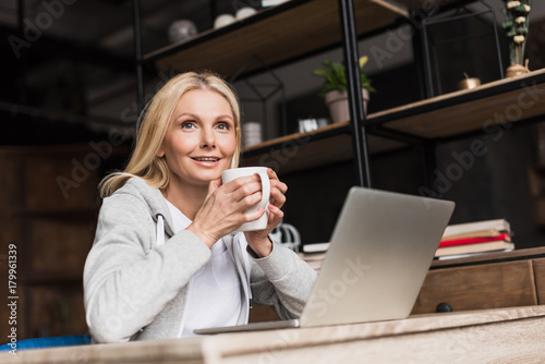 woman with coffee using laptop