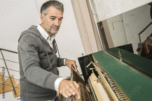 Piano technician repairing the piano photo