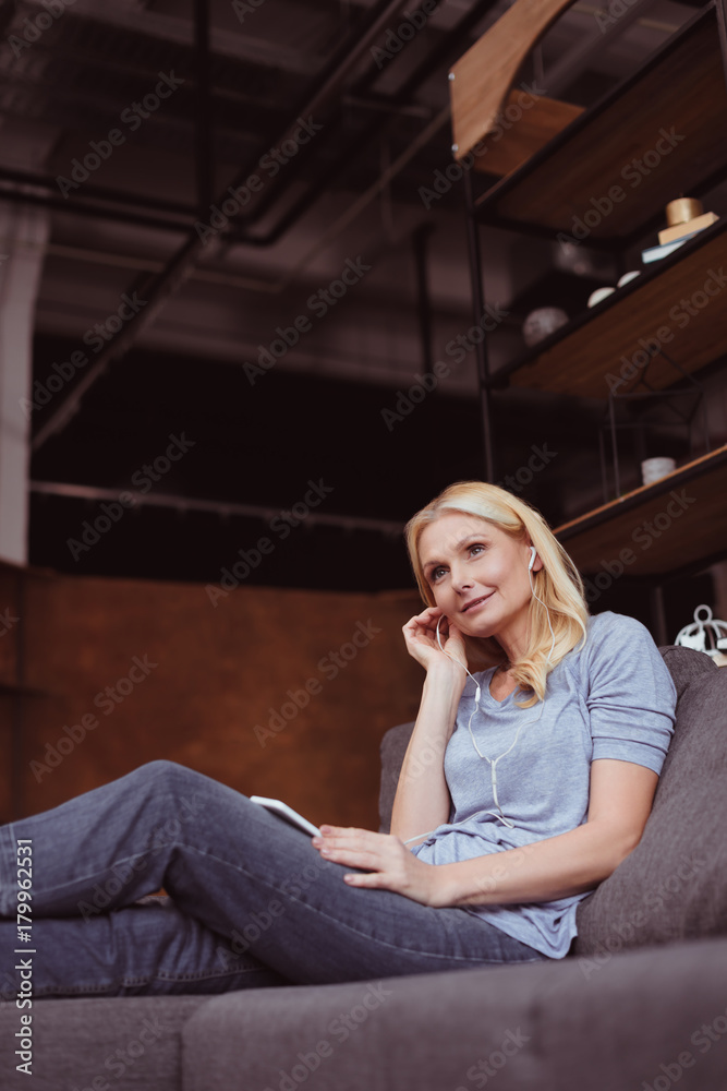 Obraz premium woman in earphones using smartphone
