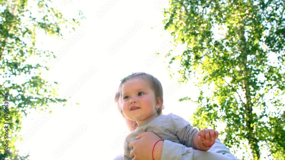A young father playing with his daughter on a sunny afternoon smiling happily in the city park. A young father playing with his daughter on a sunny afternoon smiling happily in the city park.