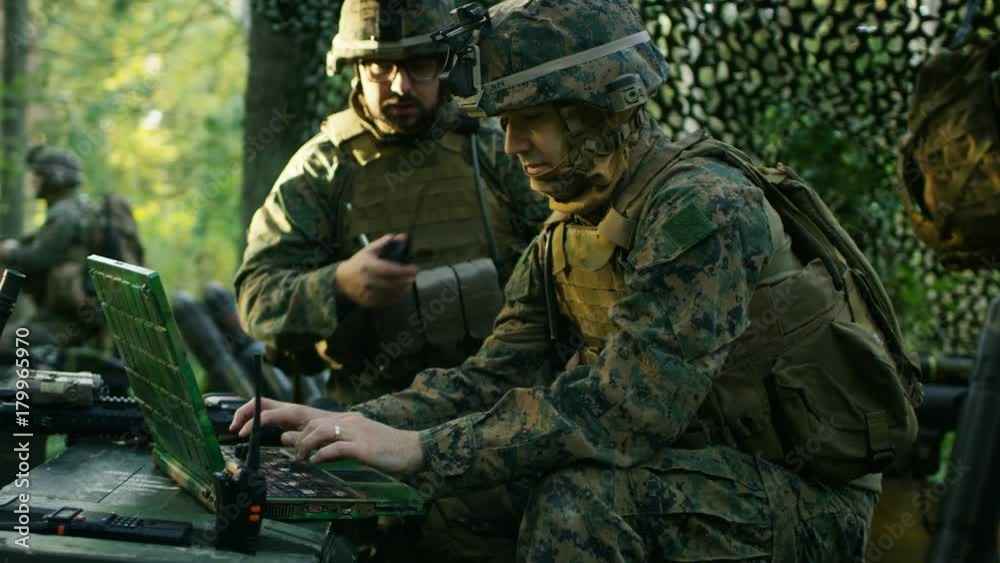 Military Staging Base, Officer Gives Orders to Chief Engineer, They Use Radio and Army Grade Laptop. They're in Camouflaged Tent in a Forest. They're on Reconnaissance Operation/ Mission.