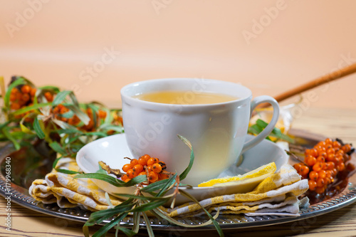 Tea made from sea buckthorn berries healthy for health delicious, saturated with vitamins surrounded by berries and sea buckthorn leaves for family tea drinking and maintaining health in the body