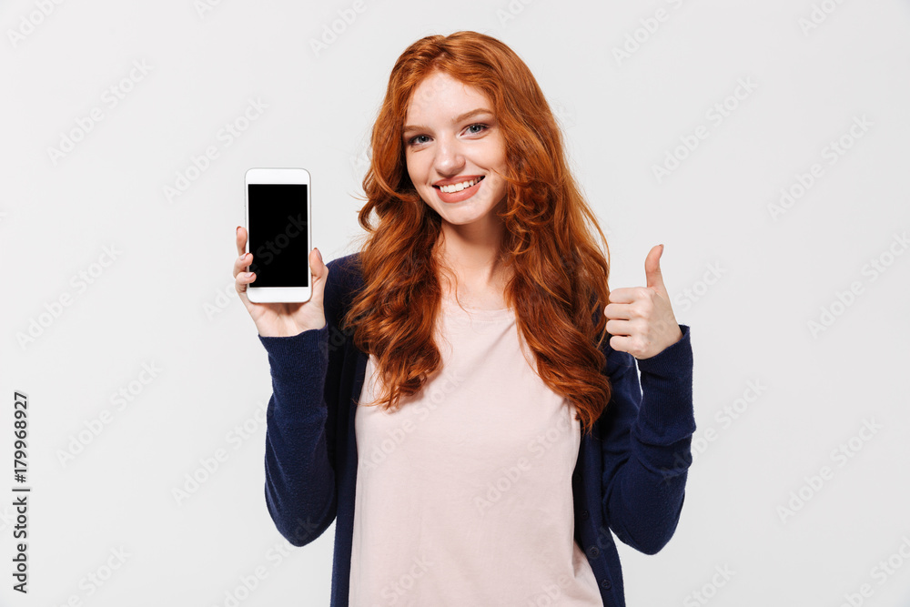 Happy young redhead lady showing display of mobile phone