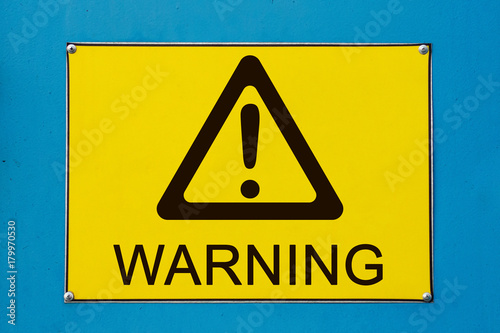 Closeup view of street warning exclamation sign on yellow metallic board
