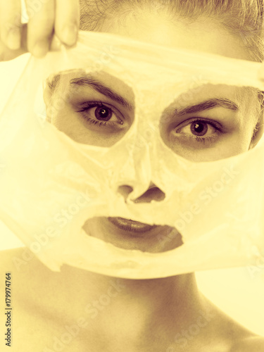 Fototapeta Naklejka Na Ścianę i Meble -  Woman removing facial peel off mask.