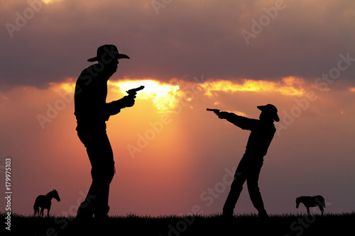 фотографія duel of cowboy at sunset