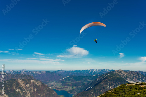 Paraglider flying in blue sky