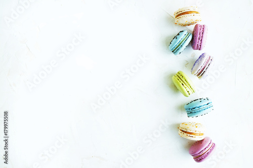 Tasty colorful macaroons in marble background. Text space. Pastel colors.