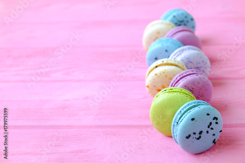 Tasty colorful macaroons in pink background. Text space. Pastel colors.